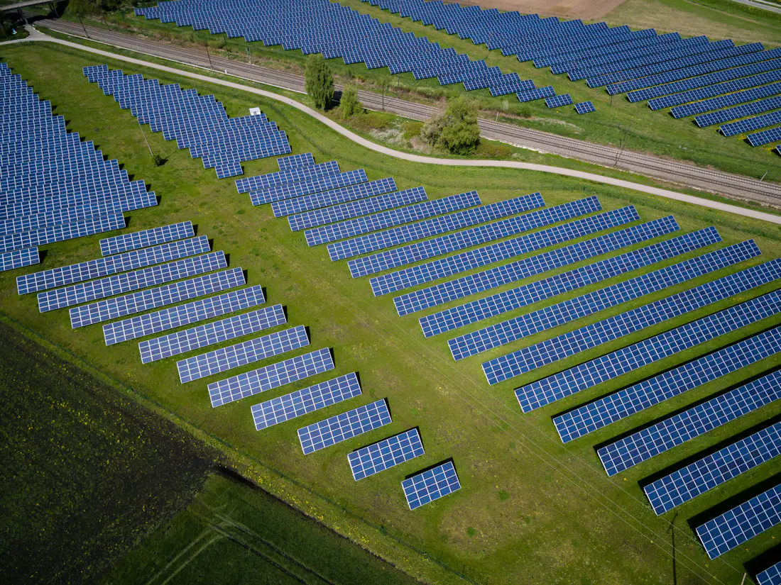 Vista aérea de una planta de energía solar rodeada de áreas verdes